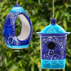 two blue and white bird houses hanging from strings