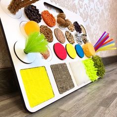 an assortment of different colored sponges and brushes on a white tray with wood flooring