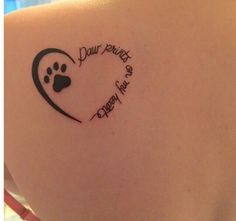 the back of a woman's shoulder with a dog paw and heart tattoo on it