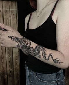 a woman with a snake tattoo on her arm