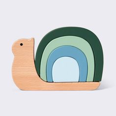 a wooden toy snail with green, blue and yellow shapes on it's back