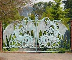 a large metal gate with two dragon heads on it's sides and an entrance