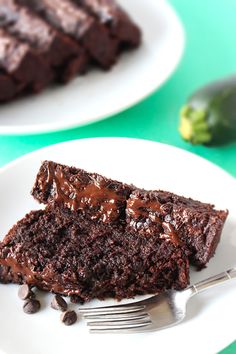 a piece of chocolate cake on a white plate with a fork next to the slice