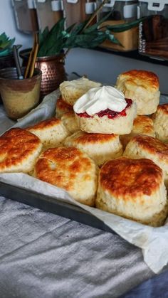 some biscuits with cream on top are sitting on a tray