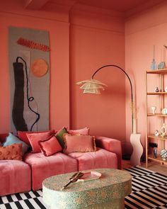 a living room with pink couches and black and white rug