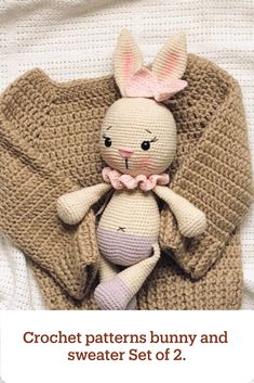 a knitted bunny doll laying on top of a blanket