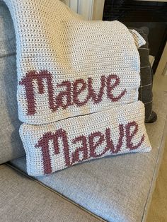 two crocheted pillows sitting on top of a couch