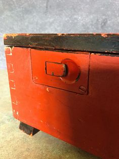 an old red suitcase is sitting on the floor