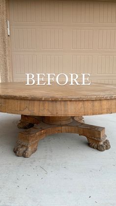 a wooden table with the words before painted on it in front of a garage door