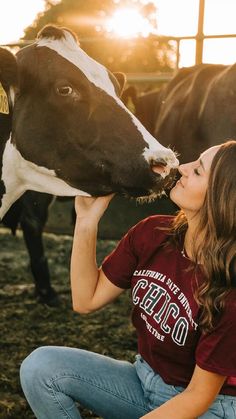 a woman is kissing a cow on the nose