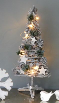 a christmas tree made out of driftwood with lights and snowflakes on it