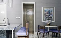 a kitchen with marble counter tops and purple chairs