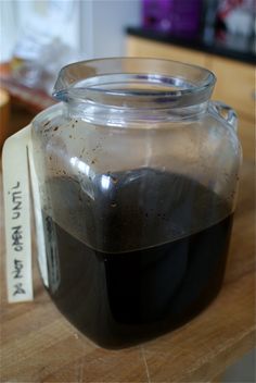 a glass jar filled with liquid sitting on top of a wooden table