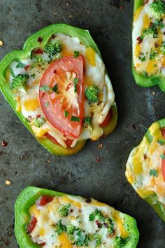 four stuffed bell peppers topped with cheese, tomatoes and broccoli