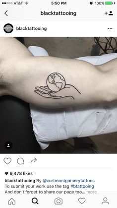 a person with a tattoo on their arm holding a small globe in his hand,