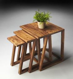 three wooden stools with a plant in the middle one on each side and another on the other