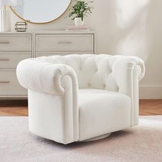 a white chair sitting on top of a rug in front of a dresser and mirror