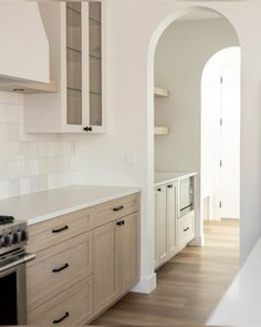 an empty kitchen with white cabinets and wood flooring is pictured in this image from the doorway