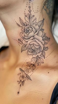 a woman's neck with flowers and leaves on the bottom part of her chest