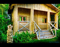 an image of a bamboo cabin in the jungle with stairs leading up to it's entrance