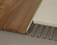 a close up of a wooden door with concrete and wood flooring next to it