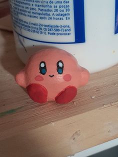 a close up of a cup on a table with a toy octopus next to it