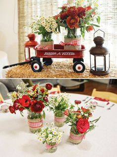 flowers in vases sitting on top of a table next to an old fashioned wagon