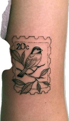 a small bird sitting on top of a stamp with leaves around it's neck