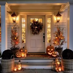 a front porch decorated for halloween with pumpkins and lanterns