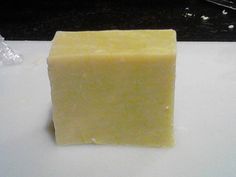 a block of yellow soap sitting on top of a white counter next to a sink