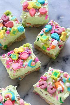 there are many pieces of cake with candy on it and sprinkles all over them