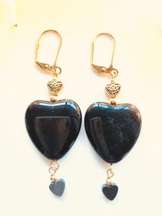 Black heart earrings--Triple hearts! These black hearts have gold hearts above them and smaller black hearts that dangle from below. Perfect for a more dramatic look or those days when only a black heart will do.  Length: 2.5 inches Black Heart Earrings For Pierced Ears As Gift, Black Heart Charm Earrings As Gift, Black Earrings With Heart Charm For Gift, Black Dangle Jewelry For Valentine's Day, Black Heart Earrings As A Gift, Black Heart Earrings With Ear Wire, Black Heart Drop Earrings For Gift, Black Heart Earrings With Heart Charm For Gift, Black Heart Beads Jewelry For Valentine's Day