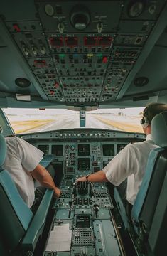 two pilots sitting in the cockpit of an airplane