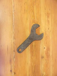 an old wrench sitting on top of a wooden table