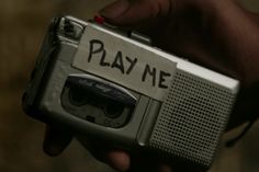 a person holding an old fashioned radio with play me written on the front and side