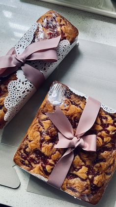 two pieces of cake with pink bows on them sitting next to each other and one piece has a fork in it