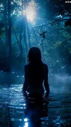 a woman is sitting in the water at night