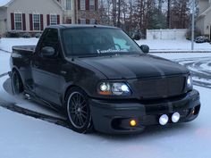 a black truck is parked in the snow