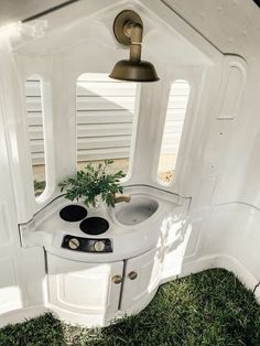 the inside of a camper with a potted plant on it's stove