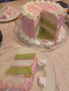 there is a cake with pink and green frosting on the plate next to it