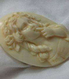 a carved ivory brooch with an image of a man's head on it