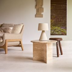 a living room filled with furniture and a lamp on top of a wooden table next to a couch