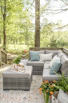 a patio with couches, tables and potted plants