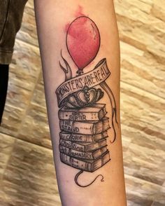 a tattoo with books and a balloon on it