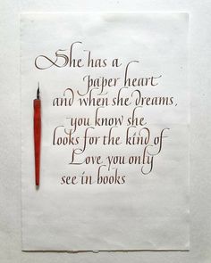 a piece of paper with writing on it and a red pen in the middle that says she has a paper heart and when she dreams, you know she looks for the kind of love