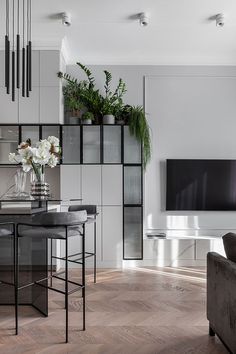 a living room filled with furniture and a flat screen tv mounted on the wall above it