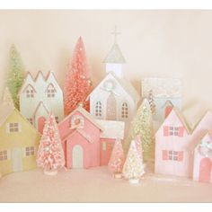 there are many small houses on the shelf next to each other, all painted pink and yellow