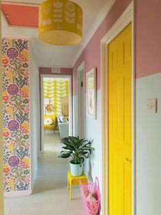 the hallway is decorated in bright colors and has a plant on the end table next to it