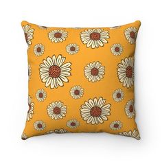 a yellow pillow with white daisies on it