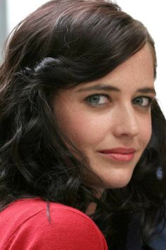 a close up of a person wearing a red shirt and black hair with blue eyes